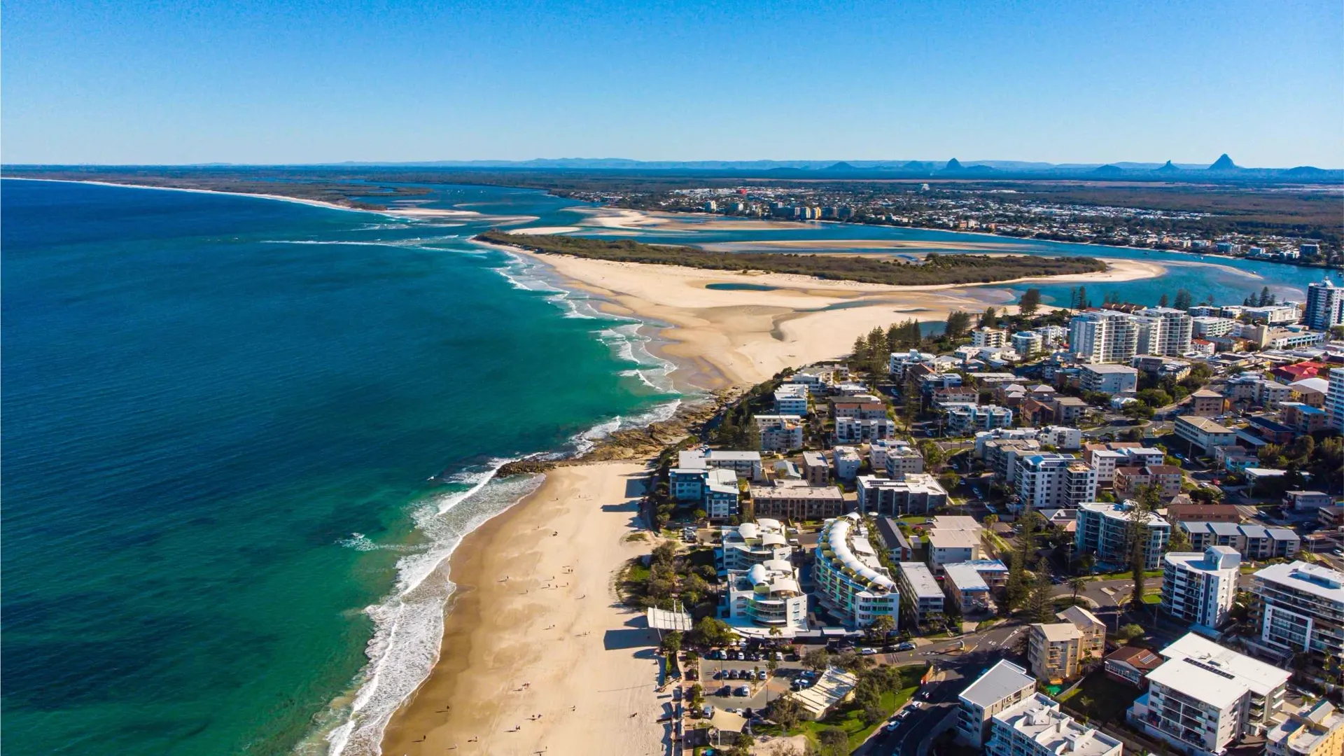Aerial view of the Sunshine Coast shoreline with the Glass House Mountains beyond
