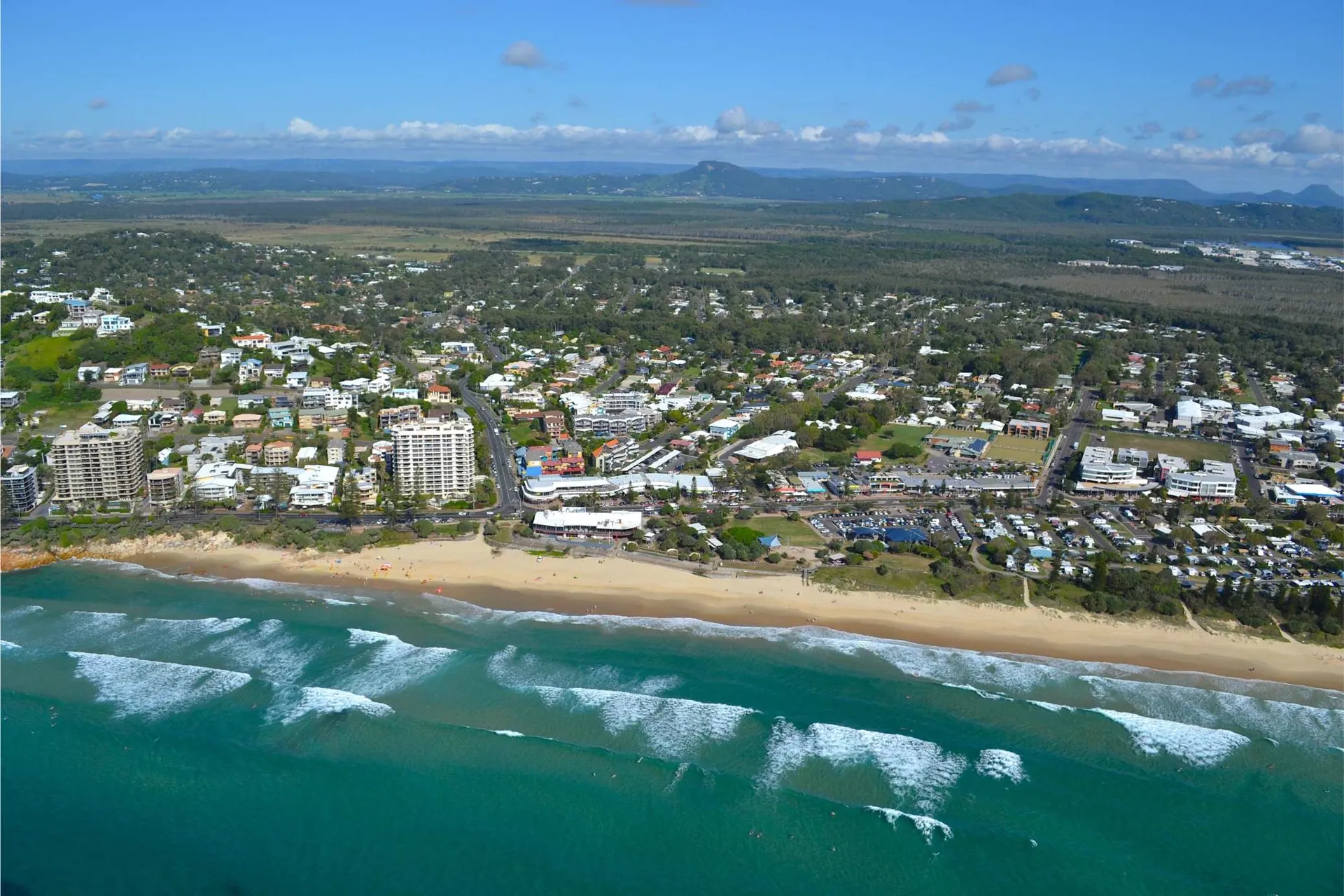 Aerial view of Coolum Beach, the surf and surrounding homes