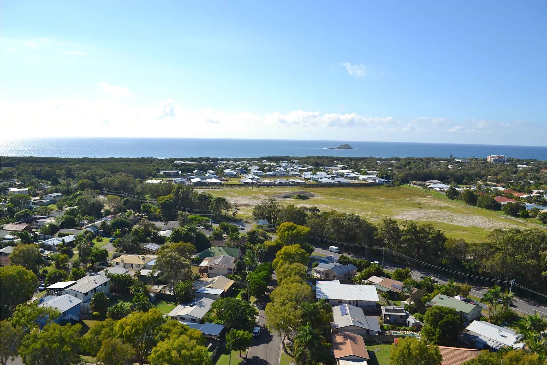 Aerial view of a leafy coastal Sunshine Coast suburb beside the ocean