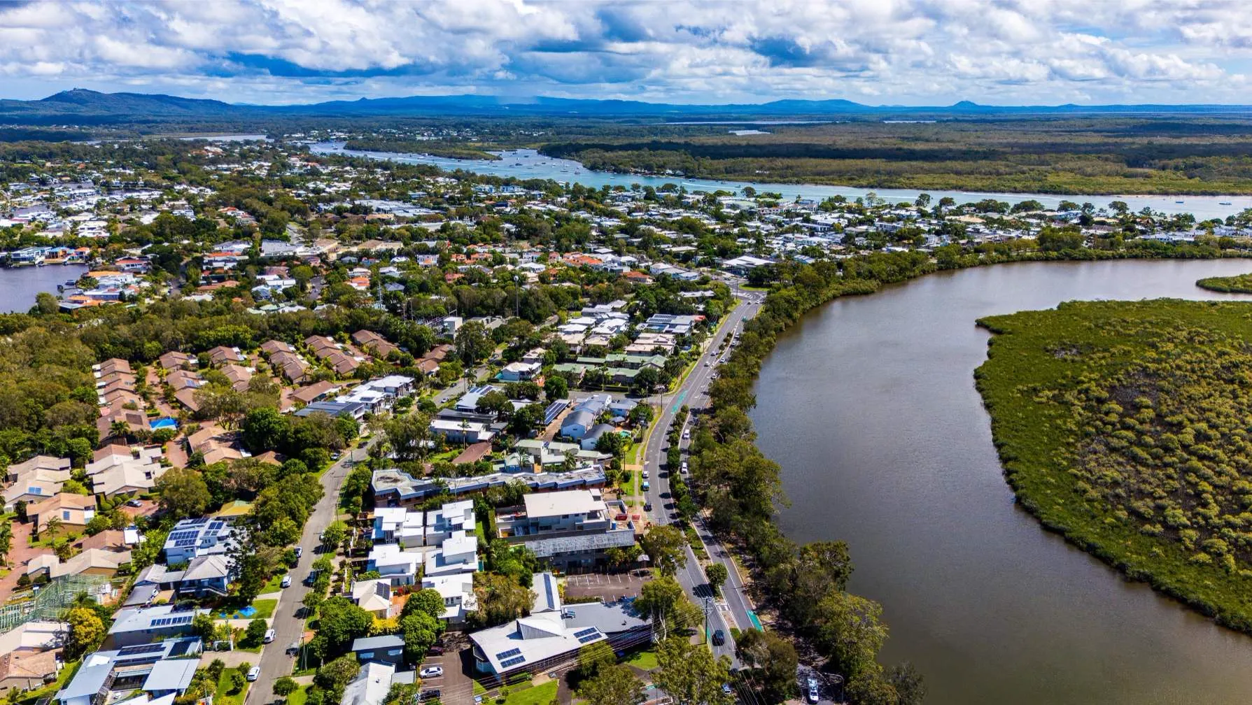 Aerial view of Noosa homes beside the river and bushland