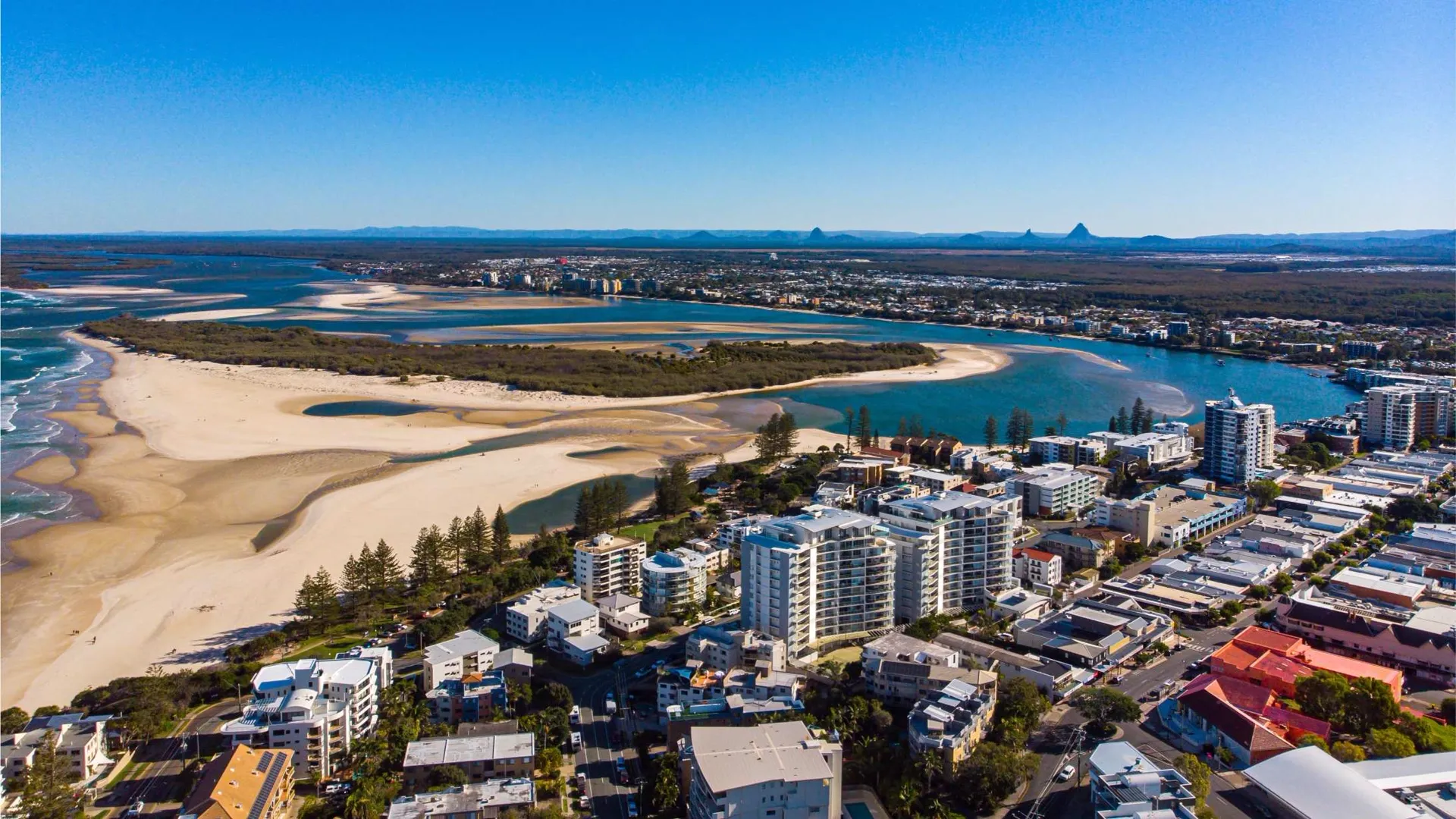 Aerial view of a Sunshine Coast river mouth, sandbar and apartments