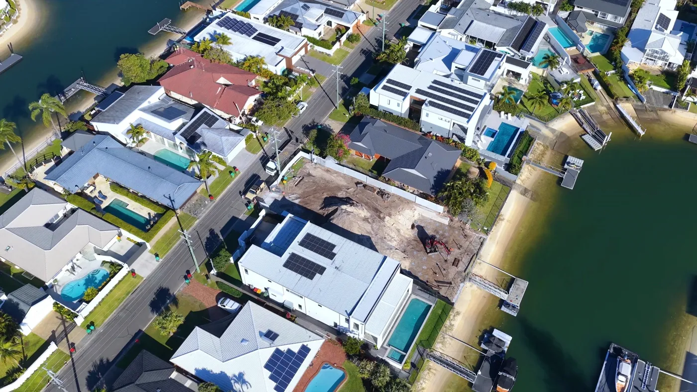 Aerial view of waterfront canal homes with pools on the Sunshine Coast