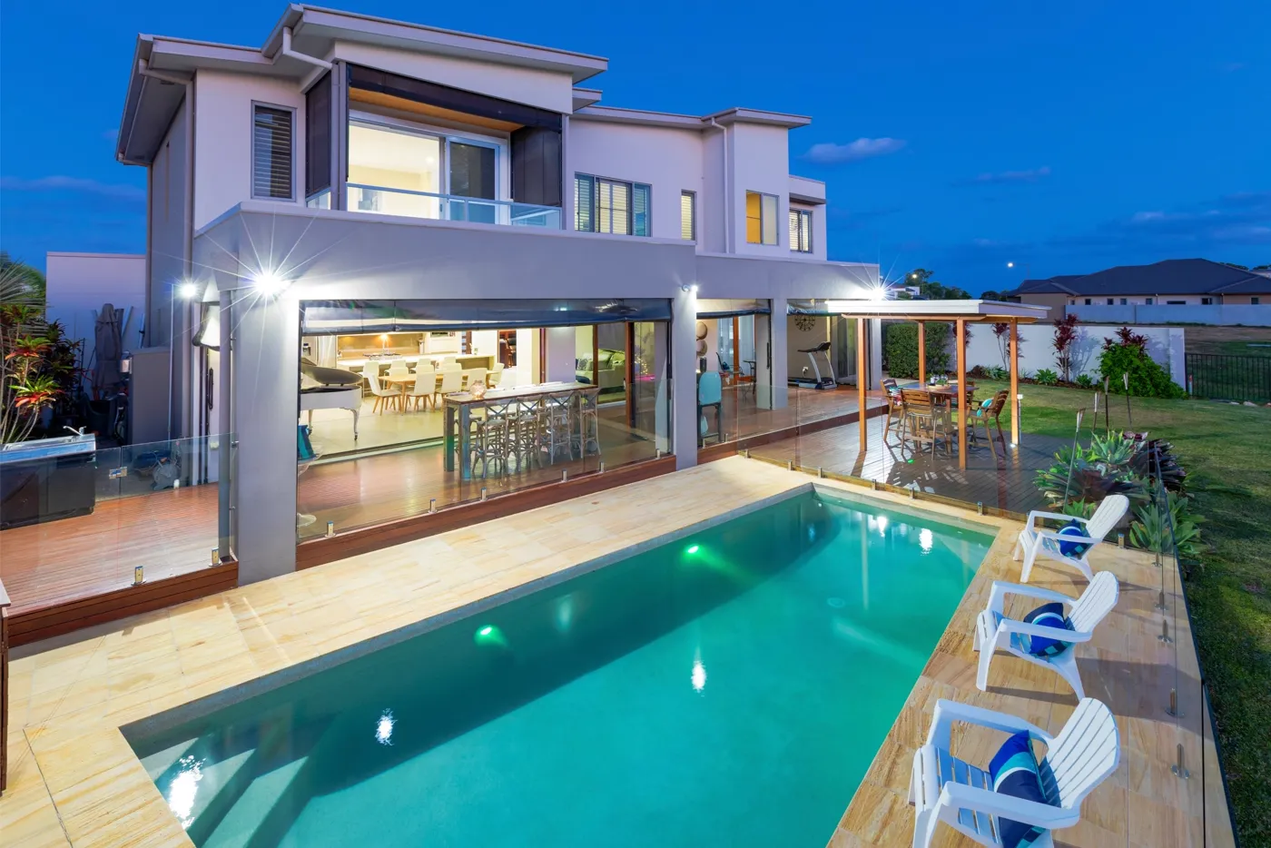 Modern two-storey Sunshine Coast home with a pool at dusk