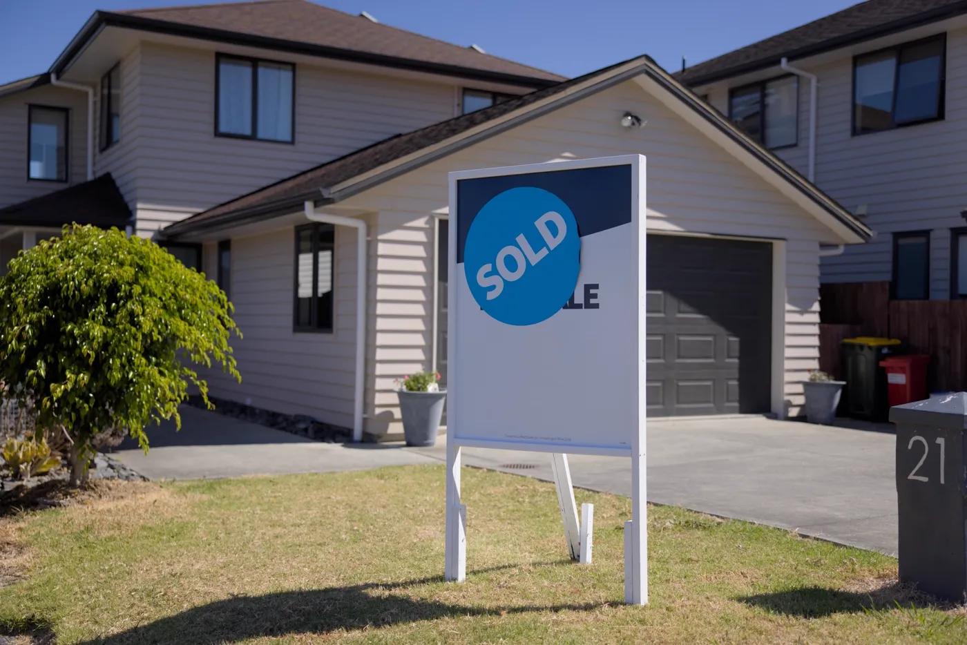Sold board in front of a weatherboard home with a front lawn